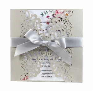 Detail of laser-cut butterfly invitation with champagne gold shimmer and satin ribbon