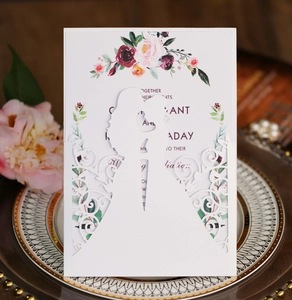 Laser cut white wedding invitation showing silhouettes of couple with floral patterns
