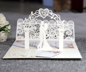 Intricate 3D laser-cut lace wedding invitation featuring a romantic couple and floral arch