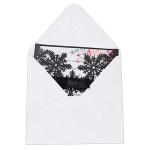 White laser-cut snowflake invitation with pink floral inner card and black satin bow