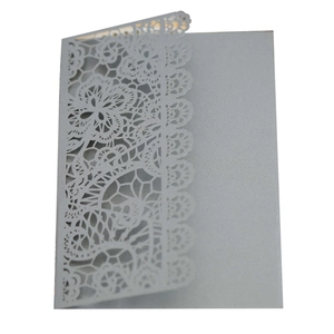 Close-up of laser-cut lace floral pattern on light grey pearlescent wedding invitation