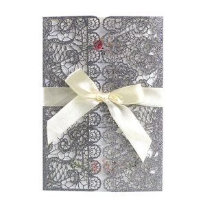 Silver glitter laser-cut lace invitation with cream silk bow and floral inner card