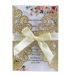 Détail d'invitation pailletée découpée au laser avec nœud satin et insert fleuri