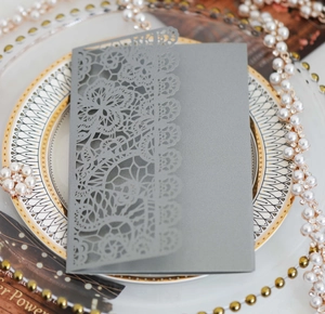 Detail of laser-cut lace floral pattern on high-quality grey pearlescent wedding invitation
