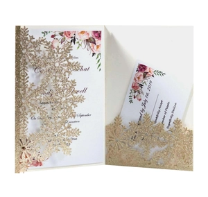 Close-up of laser-cut silver snowflake invitation with glittery floral inner card inserts