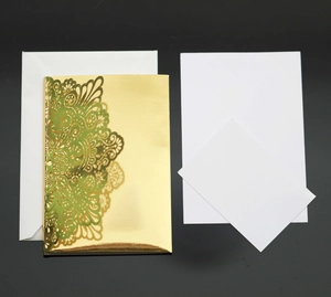 Detailed laser cut gold wedding invitation with intricate vine patterns and matching stationery
