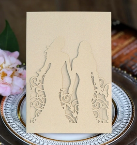Detail of laser-cut floral patterns and silhouette on a pearlized champagne wedding card