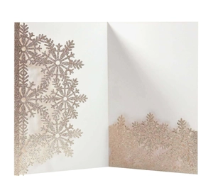 Detail of rose gold laser-cut snowflake invitation with fine glitter finish and texture