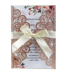 Détail d'invitation rose doré découpée au laser avec nœud satin et insert floral