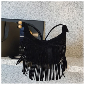 Gros plan du sac bandoulière noir à franges en daim avec des détails en perles de bois
