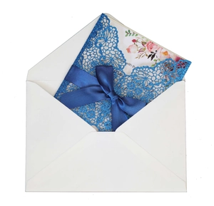 Detail showing laser cut navy blue glitter invitation cover with a satin bow and floral inner