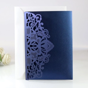 Détail d'une invitation de mariage bleu marine découpée au laser avec enveloppe blanche