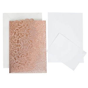 Macro view of rose gold laser-cut hollow heart invitation with glitter finish and inserts