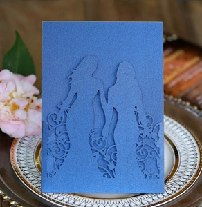 Detail of laser-cut navy blue wedding invitation featuring two girls silhouette on porcelain