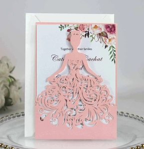 Detailed laser-cut pink wedding invitation with floral inner card and white envelope