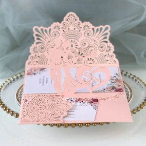 Pink laser-cut wedding invitation with hollow floral design and Mr & Mrs silhouette