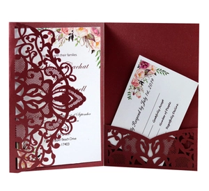 Détail macro de l'invitation de mariage bordeaux découpée au laser avec dentelle florale