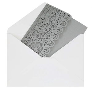Detail view of a laser-cut silver wedding invitation card with white envelope