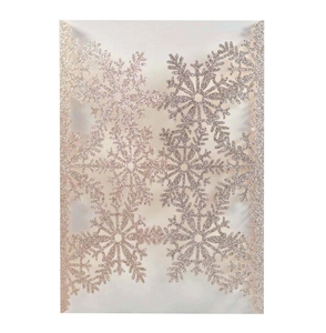 Detailed laser-cut snowflake design on champagne gold glitter wedding invitation card