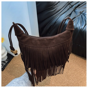 Gros plan d'un sac à franges en daim marron foncé avec perles en bois et style bohème