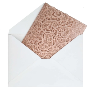 Detail of rose gold laser-cut invitation card with glitter texture and white envelope