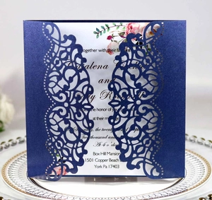 Detail of navy blue laser-cut wedding invitation shell with elegant floral inner card