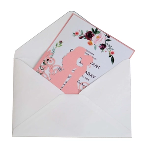 Detailed laser-cut pink wedding invitation card with floral interior and white envelope
