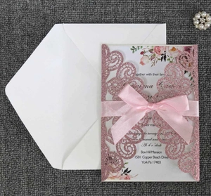 Détail d'invitation rose pailletée découpée au laser avec insert fleuri et nœud satiné