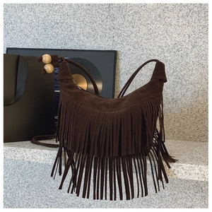 Détail d'un sac à franges en daim marron vintage avec perles en bois décoratives