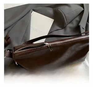 Detail of silver zipper hardware and brown matte leather texture on tote bag