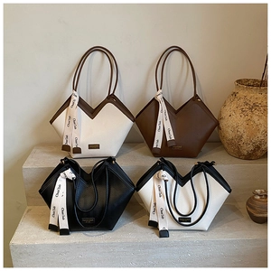 Detail of four herringbone patterned tote bags with ribbon handles on stone steps