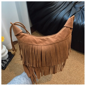 Détail d'un sac hobo en daim marron avec franges et perles en bois au style bohème