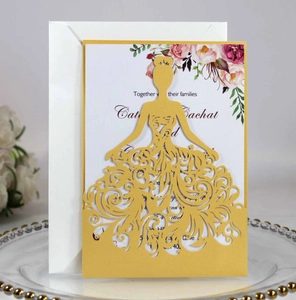 Detail of laser-cut gold wedding invitation with princess silhouette and floral inner card