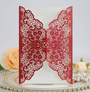 Detailed laser-cut floral pattern on red glitter wedding invitation with white inner card