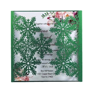 Close-up of laser-cut snowflake invitation sleeve and floral inner card with elegant textures