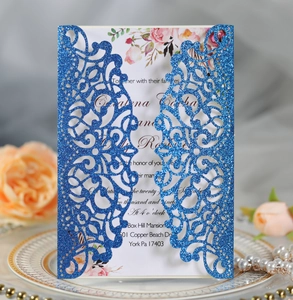 Intricate laser-cut blue glitter wedding invitation with floral printed inner card detail