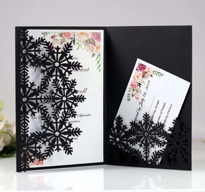 Close-up of laser-cut snowflake wedding invitation with floral insert and RSVP card
