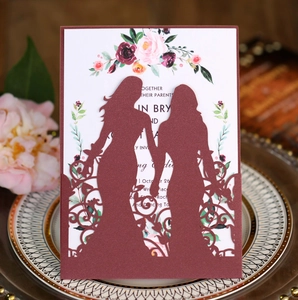 Detailed laser-cut wine red wedding invitation with two women holding hands silhouette