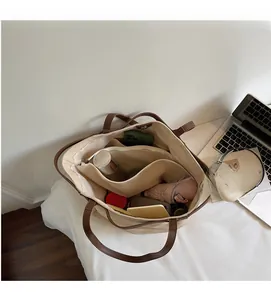 Detail view of large canvas tote bag interior with multiple daily items and laptop