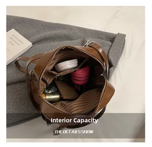 Detail showing spacious interior with striped lining and pockets of the brown leather backpack