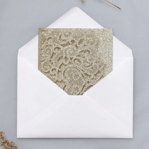 Detailed laser-cut champagne gold floral lace wedding card with sparkling glitter finish