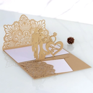 Detailed laser-cut wedding invitation featuring a 3D gold lace heart and Mr & Mrs design