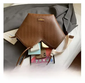 Detail showing spacious interior of brown tote bag with V-embossing and organized items