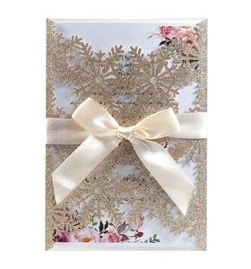 Golden glitter snowflake laser cut wedding invitation card with pink floral insert and ribbon