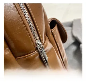 Close-up of high-quality silver metal zipper on vintage dark brown leather backpack