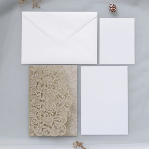 Laser-cut gold glitter wedding invitation set with elegant envelopes and blank insert cards