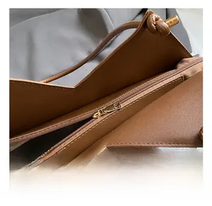 Internal detail of brown leather tote showing zipper closure and lining pocket structure