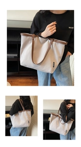 Detail of grey canvas tote bag with brown leather straps and branded woven label