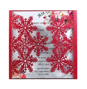 Detail of laser-cut red snowflake wedding invitation with elegant white printed inner card