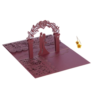 Detailed laser-cut burgundy 3D pop-up wedding card showing a romantic couple and floral arch